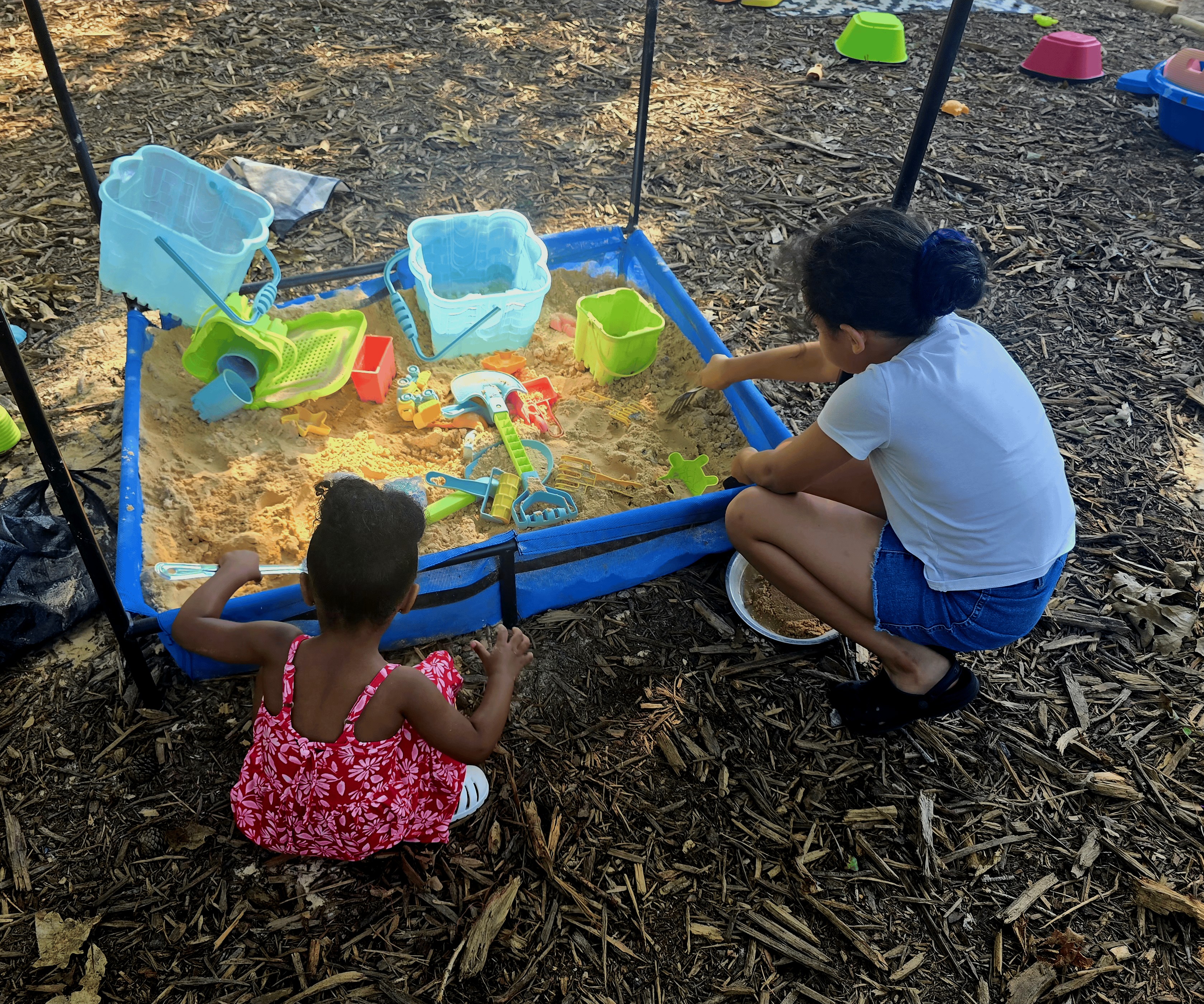 Children in a child care center playing in an outdoor sand box. 